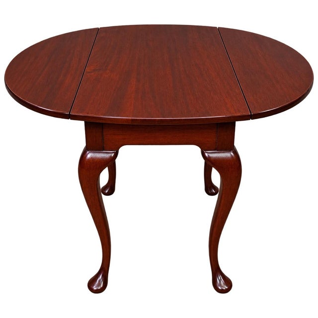 Elegant pair of traditional drop-leaf tables crafted in a rich, warm reddish-brown wood finish. Each table features a...