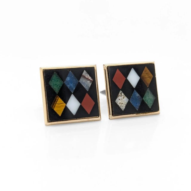 A fine pair of American Modernist cufflinks. In brass with a black hardstone ground inlaid and 6 varyingly colored,...