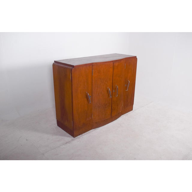 Four-door sideboard, Deco. The front is made up of four continuous doors, with slim vertical metal handles reinforcing the...