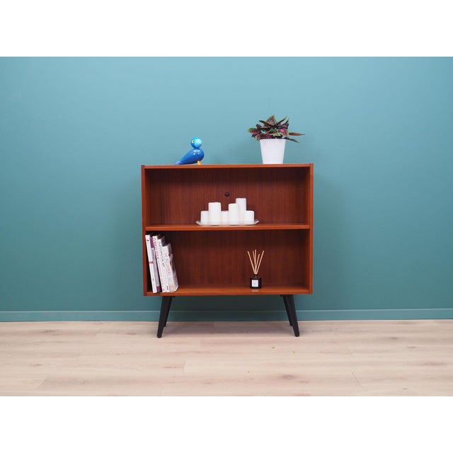 The bookcase was made in the 1970s, Danish production. The structure is covered with teak veneer. Legs made of solid wood...