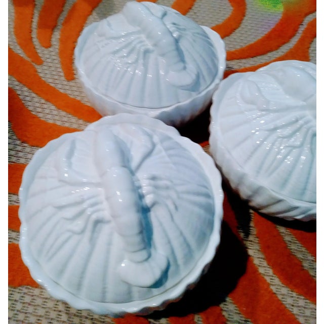 A set of 3 large white ceramic serving bowls with large lobsters on top and clamshell designed sides in the manner of Fitz...