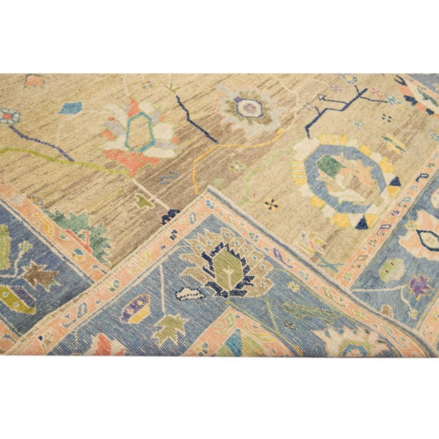 Beautiful modern Oushak hand-knotted wool rug with a Tan field. This Oushak rug has a navy blue frame and multicolor...