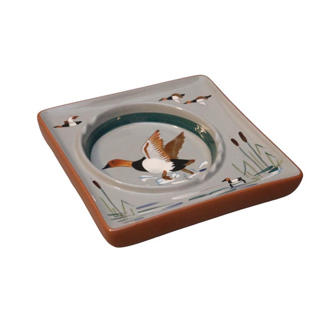 A mid-century modern ceramic ashtray made by Stangl Pottery of New Jersey. Square with an off center rounded tray, and...
