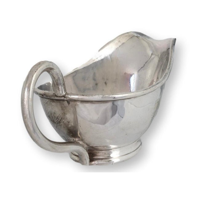 Early 20th century English hotel ware sauce boat with classic understated form and a small crest to the side. Raised on a...