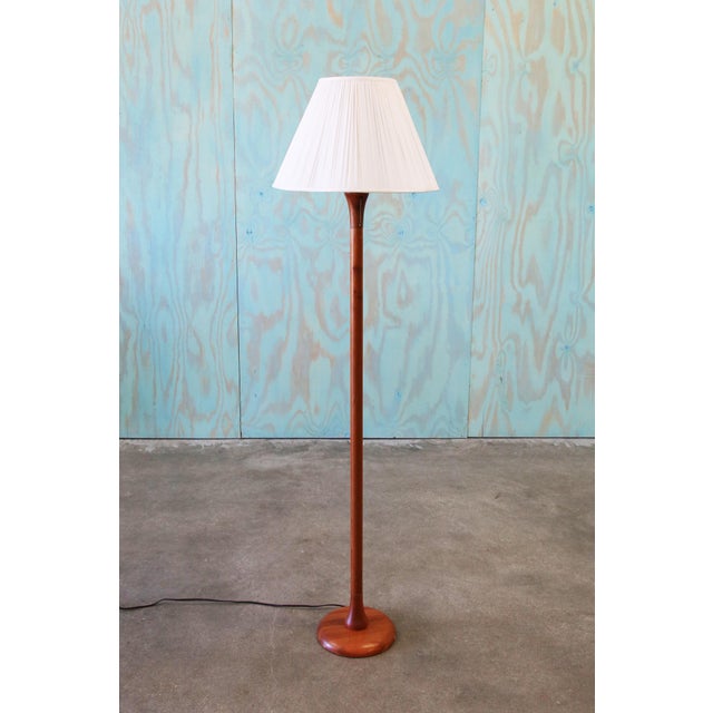 A danish modern solid teak floor lamp featuring a thick solid teak stem. The ruffled linen shade with a nod to Josef...