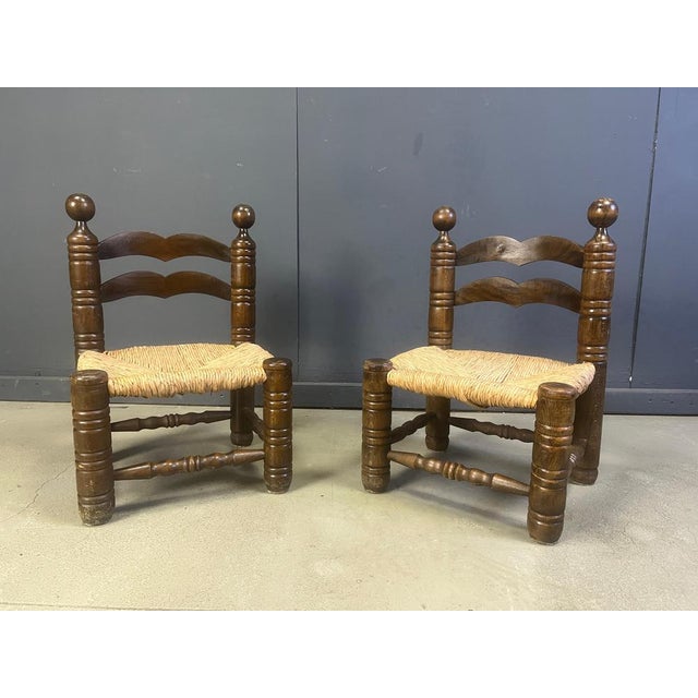 Sturdy brutalist side chairs or children chairs attributed to Charles Dudouyt. Made from stained oak and wicker seats....