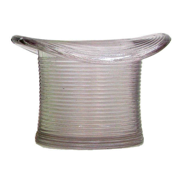 Mid 20th century glass match strike/ pyrogene. Hat form, in pale amethyst / pale pink having continuous ribbed sides onto...