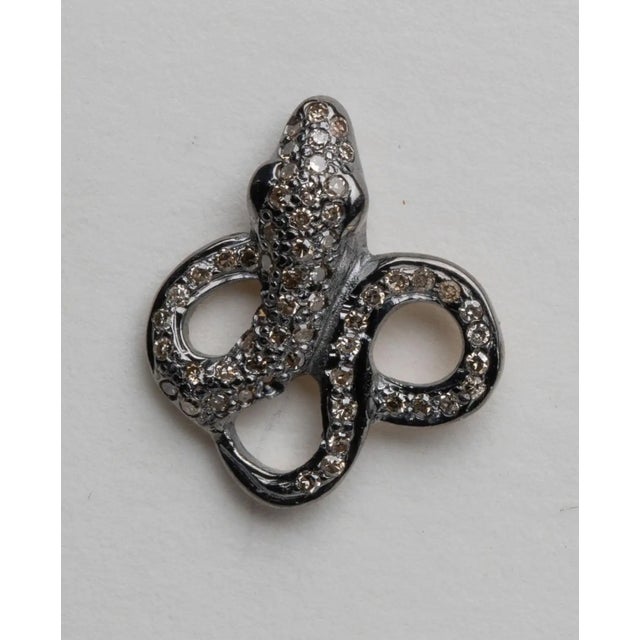 A pair of coiled snake earrings in an oxidized sterling silver set with round, brilliant cut diamonds in a pave` setting....