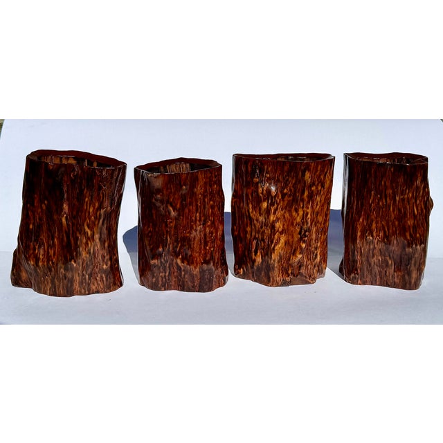 A sculptural set of four Chinese burl root wood brush pots with dramatic swirling grain and organic tree-trunk form. A...