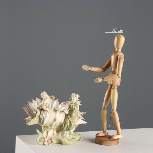 Art Nouveau polychrome porcelain vase in the shape of a shell with a nymph and a cherub. Probably Austrian. This piece is...