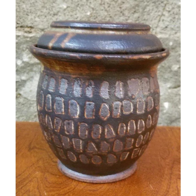 A Mid-Century Modern lidded pottery vase with geometric pattern by San Francisco artist Herman Roderick Volz. Signed on...