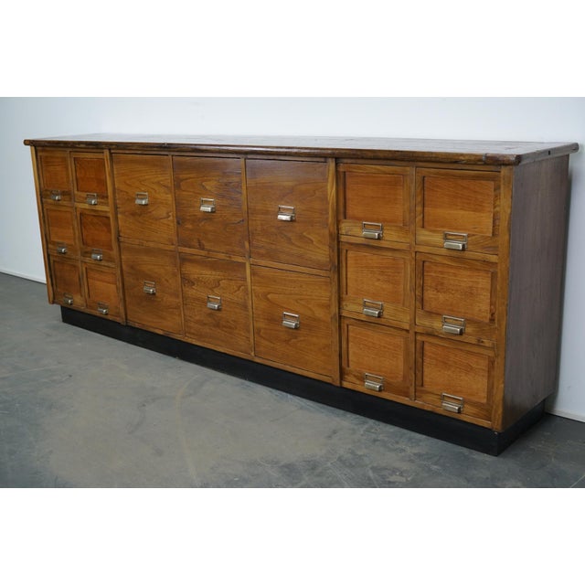 This large apothecary cabinet was made in france, circa 1950s. It features 21 drawers in two sizes with nice metal...