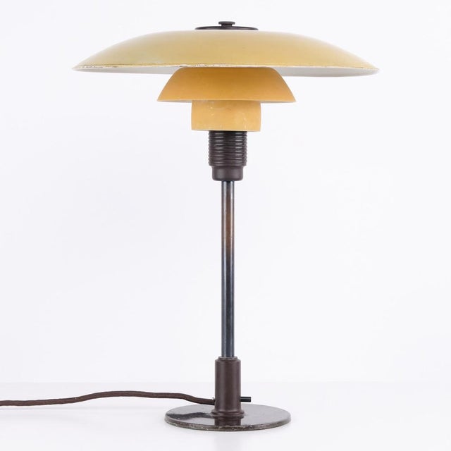 Ph 3½/2½ table lamp designed by poul henningsen and manufactured by louis poulsen in the 1930s. The lamp features a yellow...