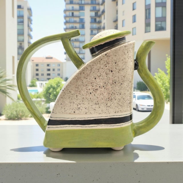 A signed postmodern studio ceramic teapot attributed to D. Kite, distinguished by a sharply geometric silhouette and...