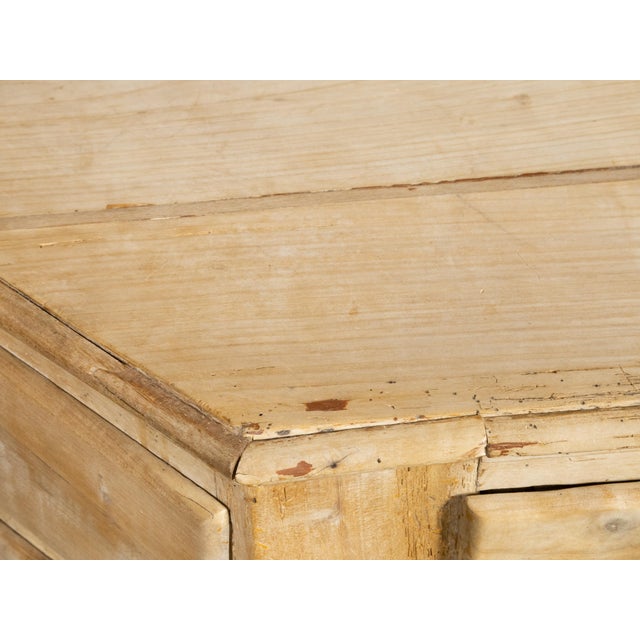 An Italian bleached wood credenza from the early 19th century, with canted sides, three drawers over four doors. Created...
