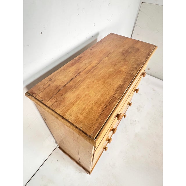 A well proportioned antique scrubbed pine chest of drawers, English and dating to about 1860. Features doorknob pulls and...
