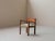 This solid wood armchair features an architectural structure resting on a straight base with clean, balanced lines. The...