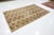 Beautiful antique Khotan hand-knotted wool rug with a Tan color field. This piece has a gorgeous floral pattern design...