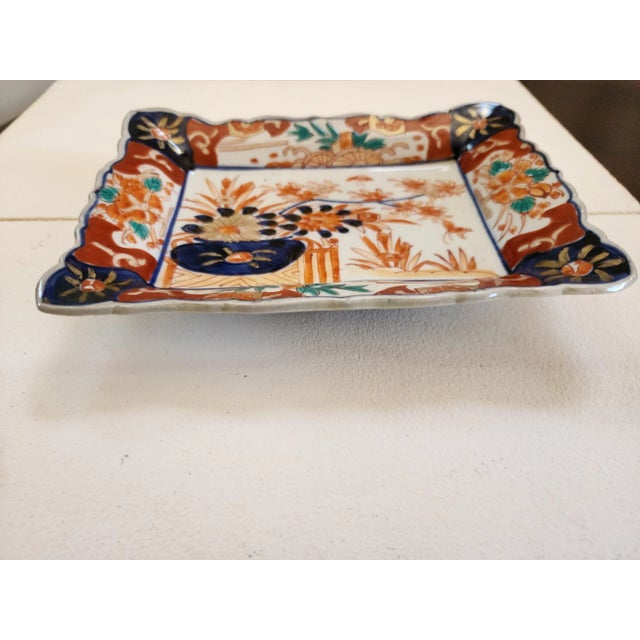 This a nice combination of colors and painted flowers. The orange color goes great with the blue. It has a circular footed...