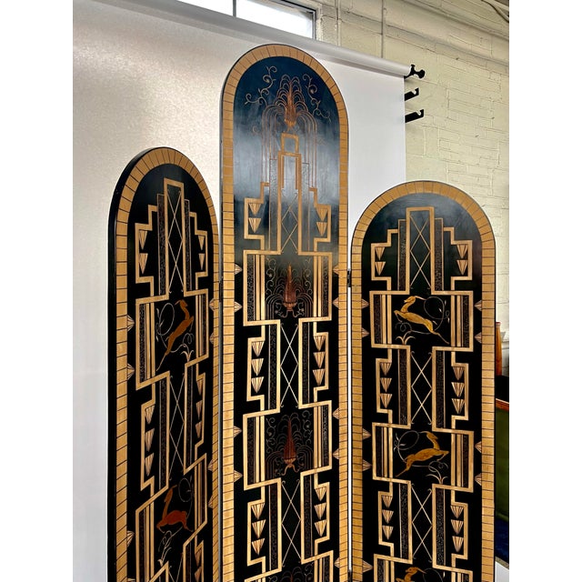 Beautiful, ornate, black and gold art deco room divider screen, in the manner of E Brandt. Three folding panels with...