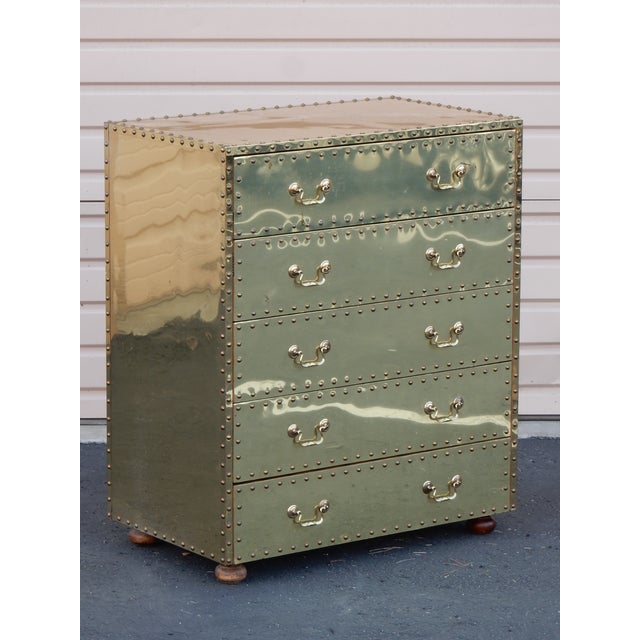 Rare, 5 drawer chest of drawers by Sarreid of Spain. Mahogany type wood frame clad in polished brass and trimmed in large...