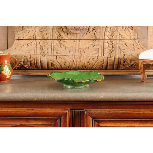 A French Provincial green glazed pottery Hors d'Œuvres dish from the mid 19th century, with scalloped edges and orange...