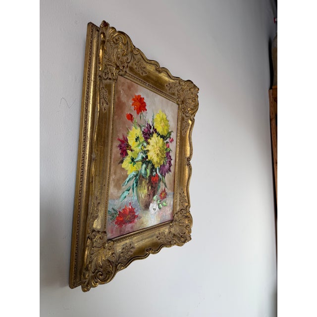 A charming vintage floral still life oil painting featuring a vibrant bouquet of blooming flowers arranged in a vase. Rich...