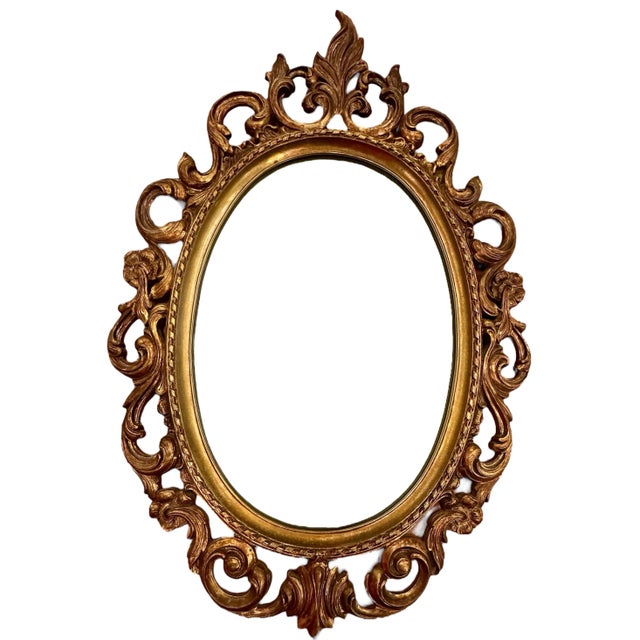 Vintage Syroco mirror with a beautiful ornate design. Great mid century bronze gold with a hollywood regency design. Made...