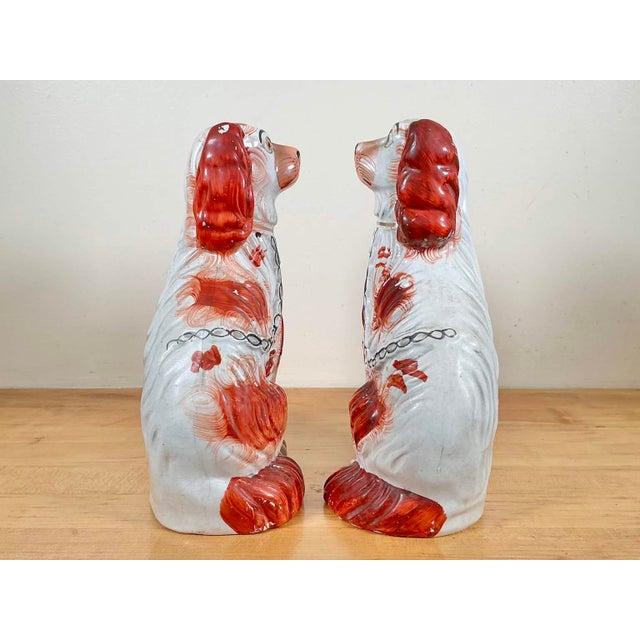 Right and left ceramic dogs figurines feature a white base coat with hand painted rust-colored patches. 5.75” (length) x...