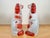 Right and left ceramic dogs figurines feature a white base coat with hand painted rust-colored patches. 5.75” (length) x...