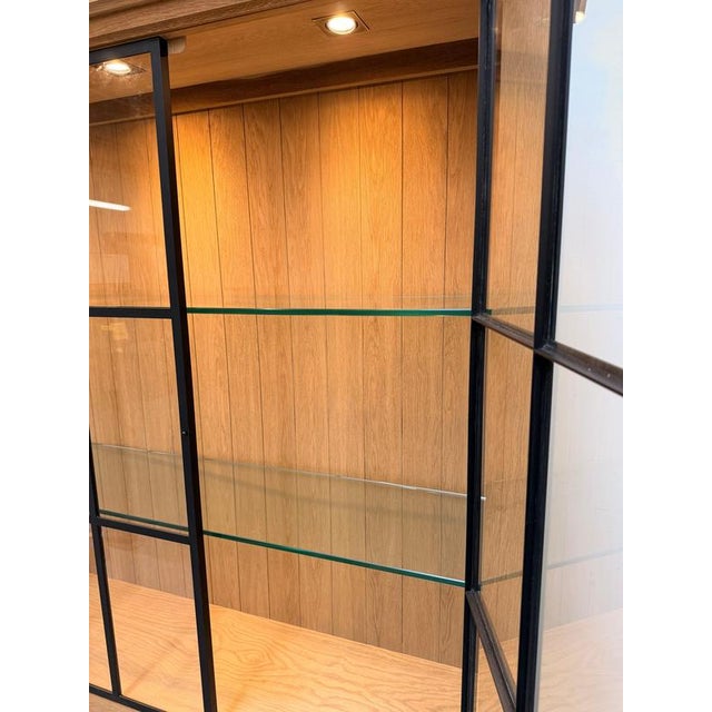 Impressive Iron Jason display cabinet by Flamant Interiors , combining warm natural oak with black metal-framed glass...