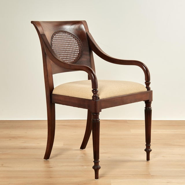 Impressive set of eight dining chairs crafted in mahogany with four arm and four side chairs in classic form featuring...