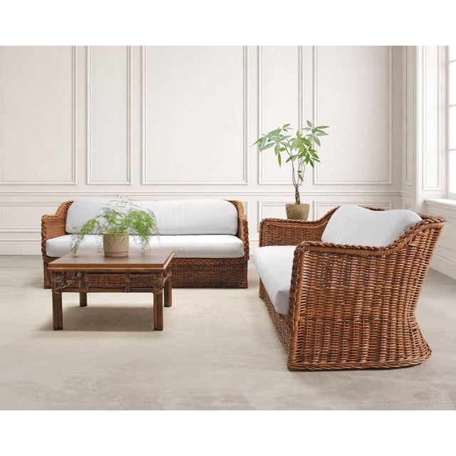 A beautifully crafted pair of woven rattan wicker sofas designed in the manner and style of Michael Taylor by The Wicker...