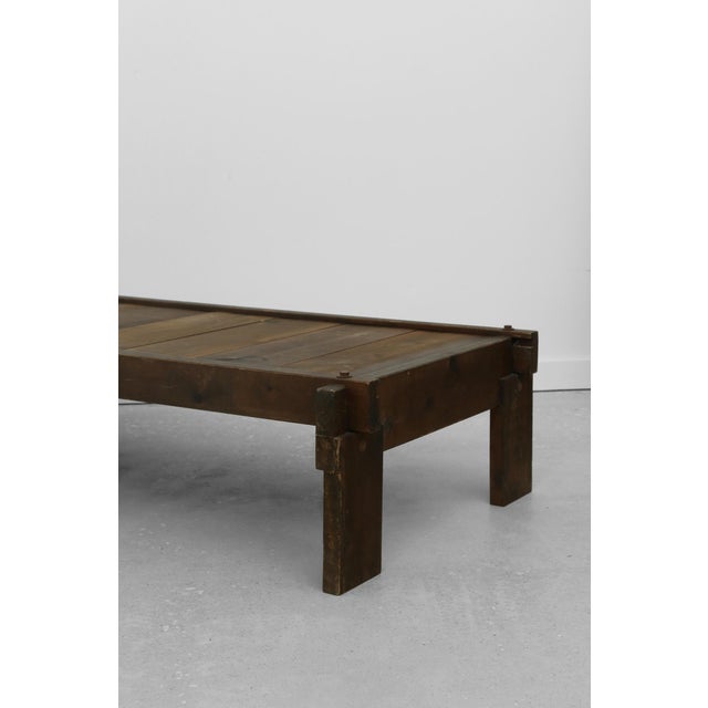 Low coffee table constructed from solid wood planks with a warm, timeworn finish. Defined by a thick rectangular top,...