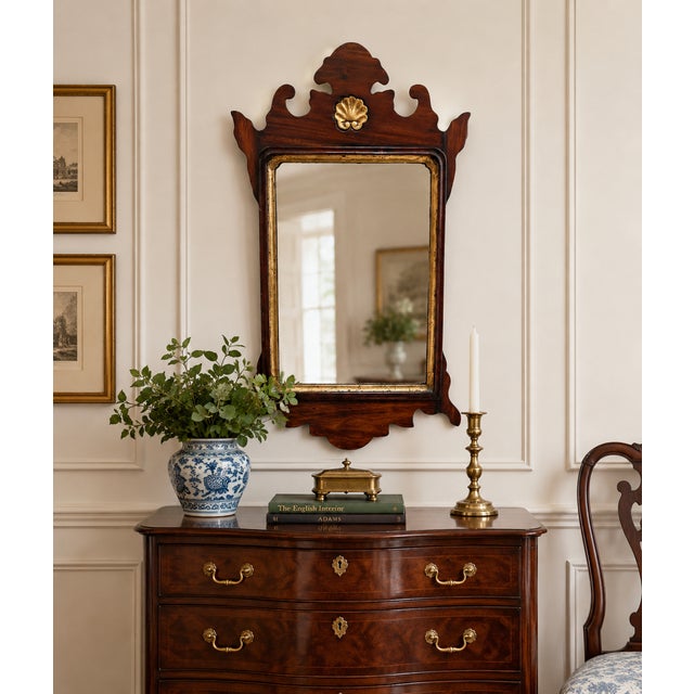 Vintage Chippendale-style mahogany wall mirror, circa 1950, featuring a beautifully shaped fretwork frame with scrolling...