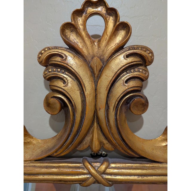 Antique, gold-gilded mirror by Harrison & Gil. It features a carved wood scroll design with acanthus leaf details,...