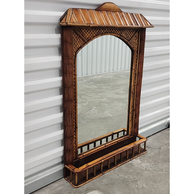 Very unique handcrafted British Colonial style bamboo and rattan Pagoda style mirror with shelf. The mirror is framed with...