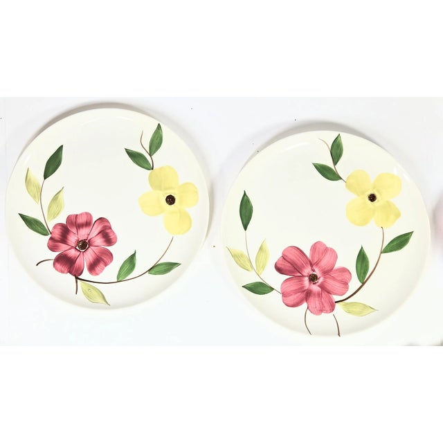 Handpainted pink and yellow dogwood flowers spill over eight mid century china plates. There are no chips or cracks but...