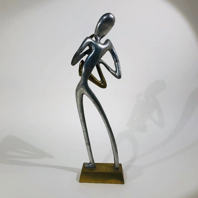Very rare 1960s aluminum figure playing a brass saxophone. This modern minimalist figure is a most charming piece to add...