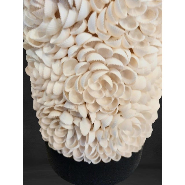 A pair of beautiful cylindrical seashell encrusted table lamps. The lamps have a round dark stained wood base and top. The...