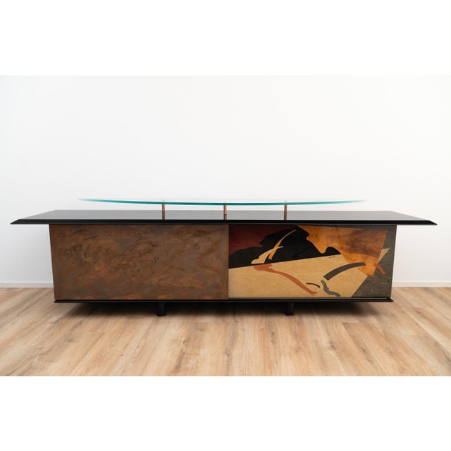 A unique piece by Carlo Malnati. This sideboard is made out black coated wood and comes with a floating glass riser on top...