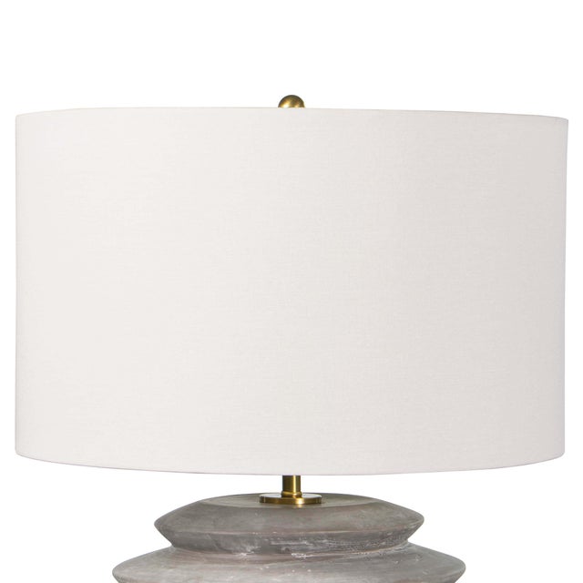 The body of this ceramic table lamp has an earthenware feel, making it stand like a modern heirloom in a living room or...