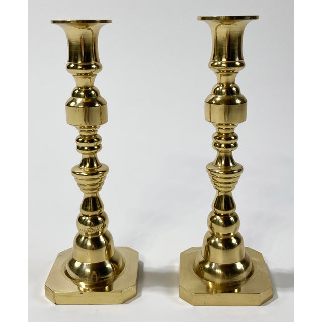 Pair of antique 19th C English brass candlesticks featuring elegant inverted beehive form. Each holds a single taper....