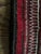 A striking handwoven rug featuring a rich and vibrant palette of deep red, burgundy, black and ivory. Its intricate...