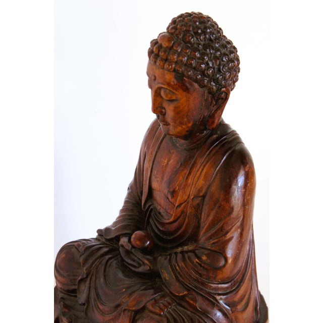 Elevate your space with this substantial 16" seated Buddha statue, entirely hand carved fro solid Asian hardwood....