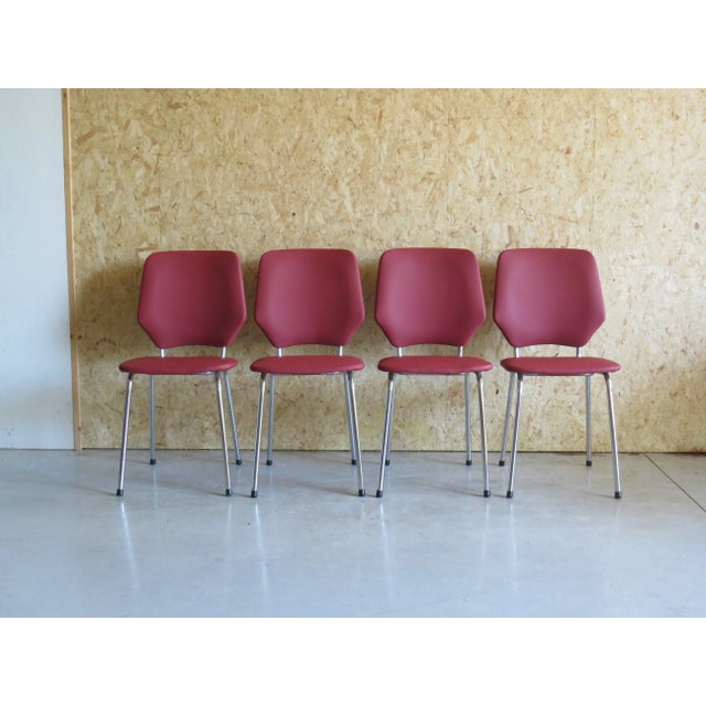 The chairs have a frame made of chrome-plated metal tubing and a leatherette seat and back with a leather print in dark...