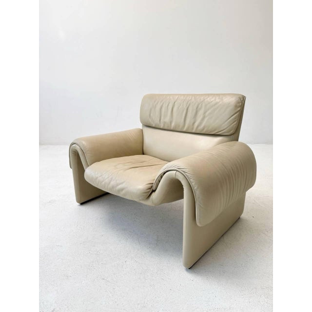 The ivory-colored ds-2011/01 armchair by de sede is an elegant and comfortable piece of furniture distinguished by...