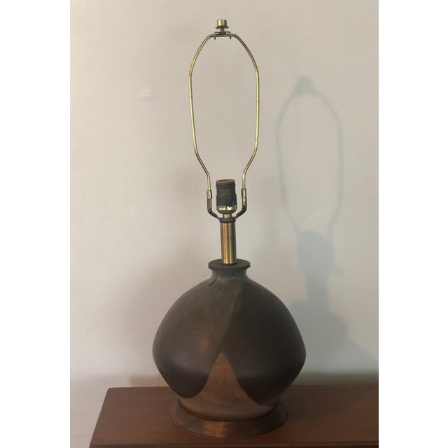 True vintage studio pottery lamp in the style of David Cressey. A beautifully formed lamp body with flame glaze sits on a...