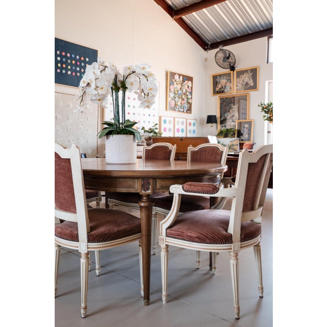 A classic French set of six Louis XVI style dining chairs, including two armchairs and four side chairs. Each features a...