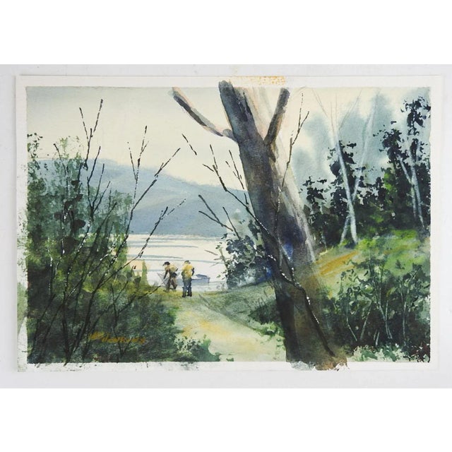 Vintage late 20th century watercolor on paper painting of two fishermen launching a boat at lakeside with forest...
